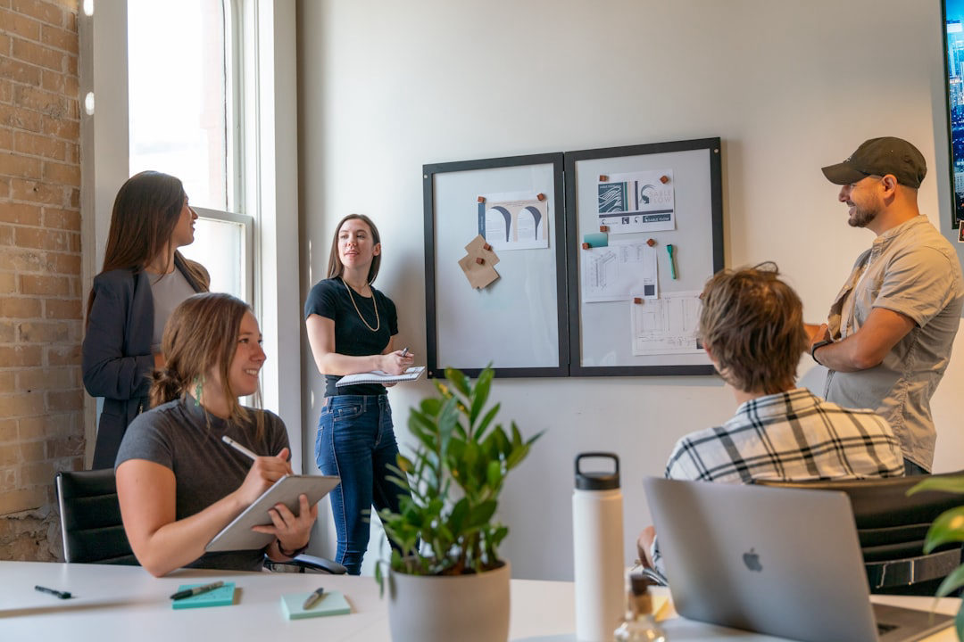 A team of marketing professionals reviewing strategy documents and designs pinned to a board during a meeting — the kind of collaborative evaluation session you'd expect when vetting an AI marketing agency.