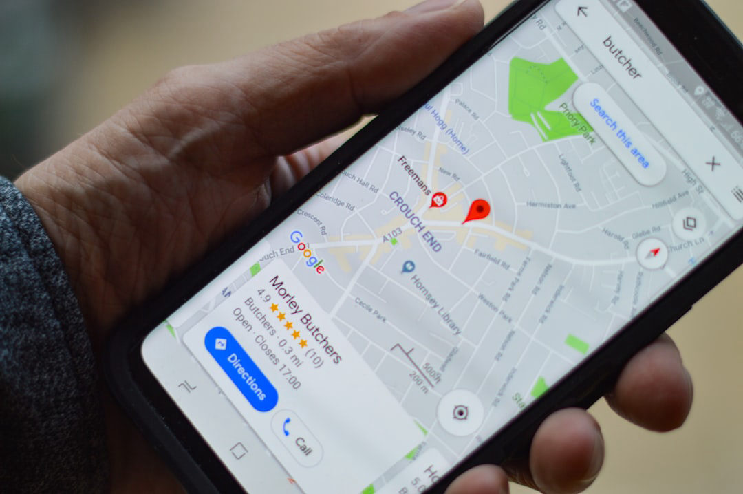 A hand holding a smartphone displaying Google Maps with a pinned local business location, illustrating how businesses appear in the google map pack
