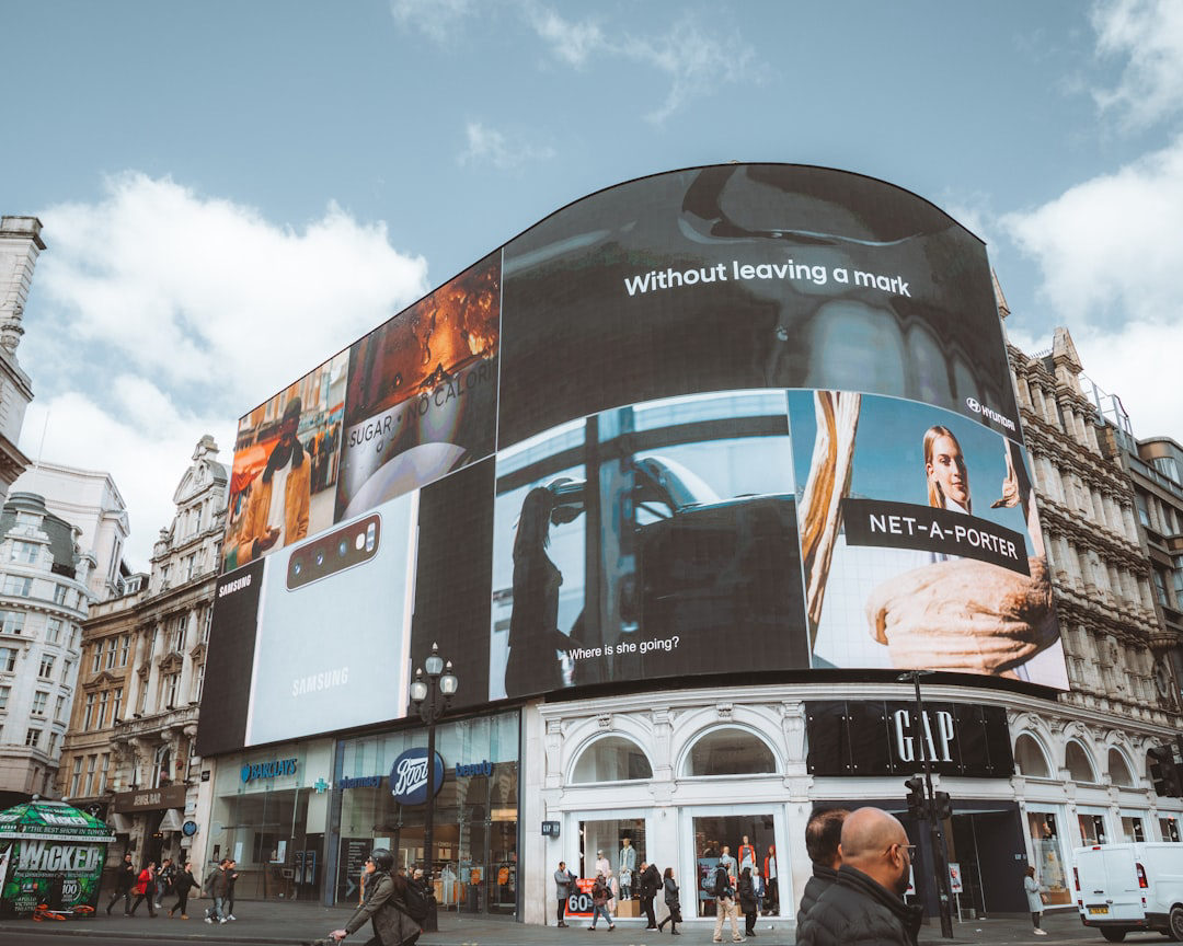 Large curved digital billboard screens displaying multiple ads on a city building, illustrating the landscape of ott vs ctv advertising